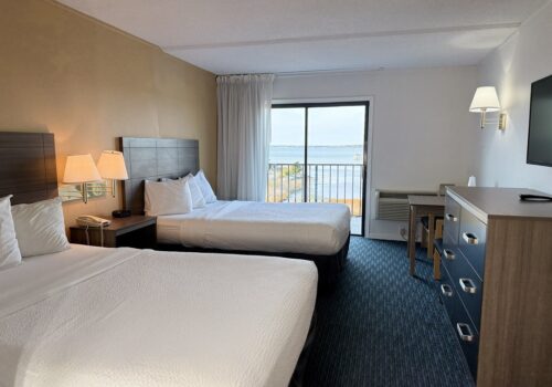 bayfront-dd-2025 2 clean white beds and a beautiful ocean view outside the window